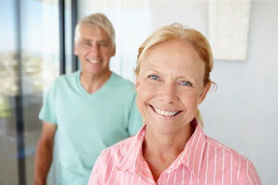 woman smiling with her husband after getting dental implants in Chatsworth, CA