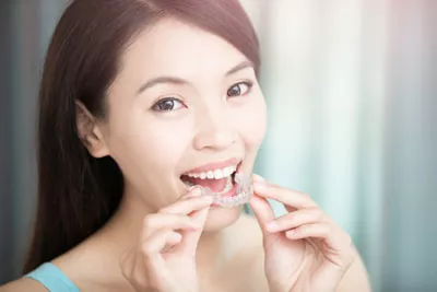 woman putting in her new Invisalign clear aligners