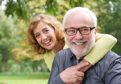 man smiling with his wife after getting dental crowns at Chatsworth Dental Group