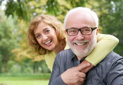 man smiling with his wife after getting dental crowns at Chatsworth Dental Group
